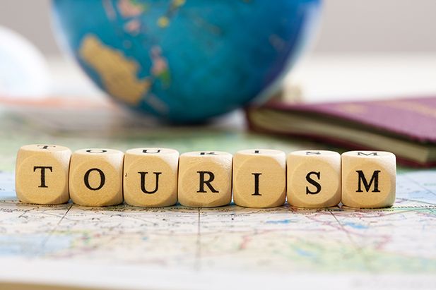 Træklodser med ordet Tourism og en globus i baggrunden