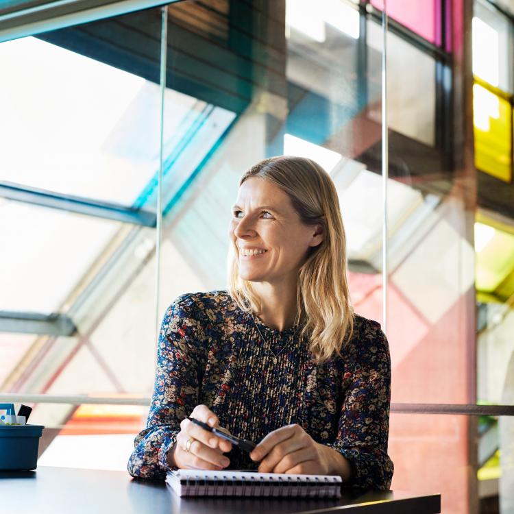 Portræt af Charlotte Matthiesen ved et vindue i et moderne interiør