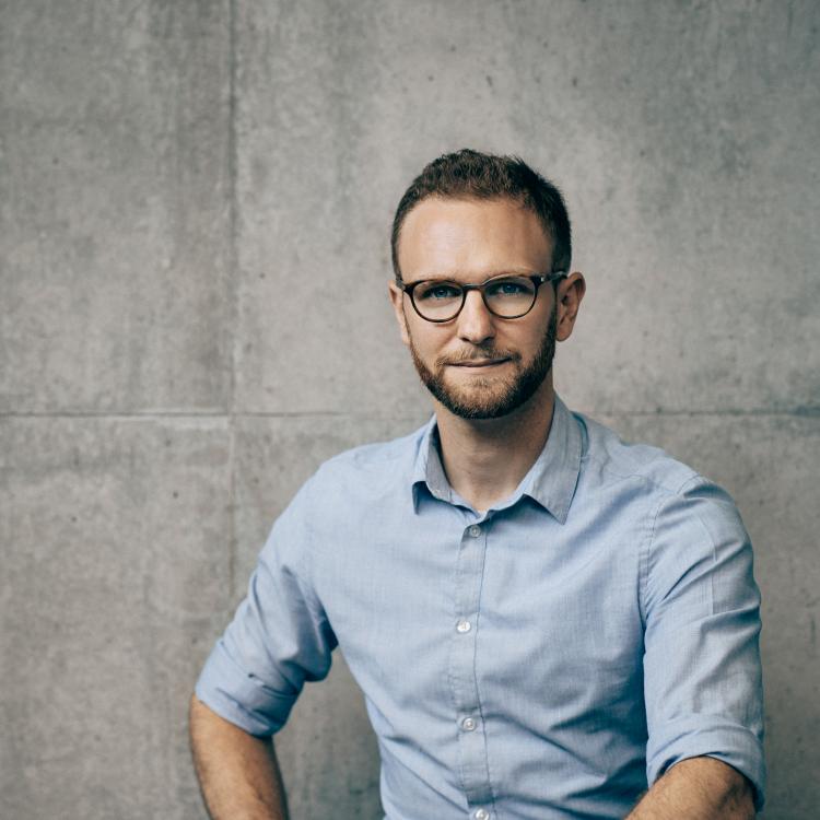Portræt af Claus Dahl foran en betonvæg