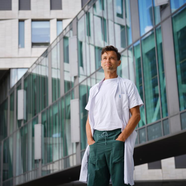 Portrait of Kasper Aaboe in front of a building with a glass façade