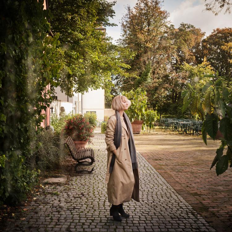 Portræt i profil af Mille Herskind i grønne omgivelser