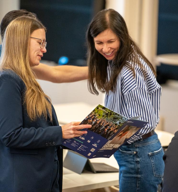 Image of CBS EMBA Participants looking at the Brochure