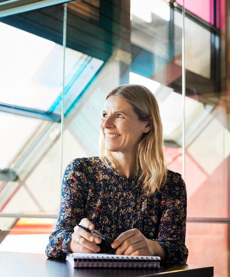 Portræt af Charlotte Matthiesen ved et vindue i et moderne interiør