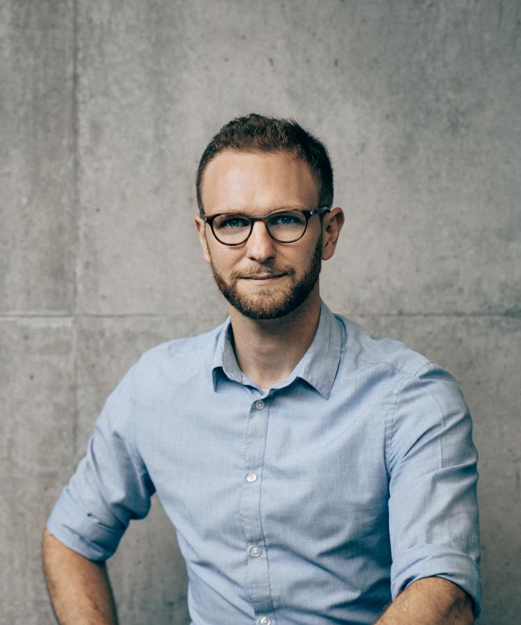 Portræt af Claus Dahl foran en betonvæg