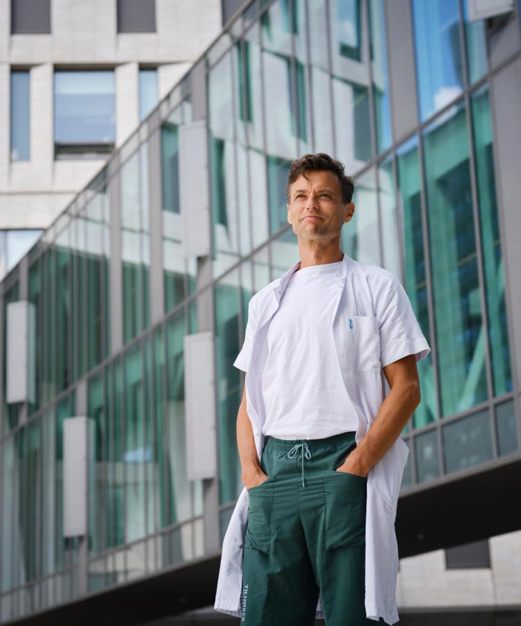 Portrait of Kasper Aaboe in front of a building with a glass façade