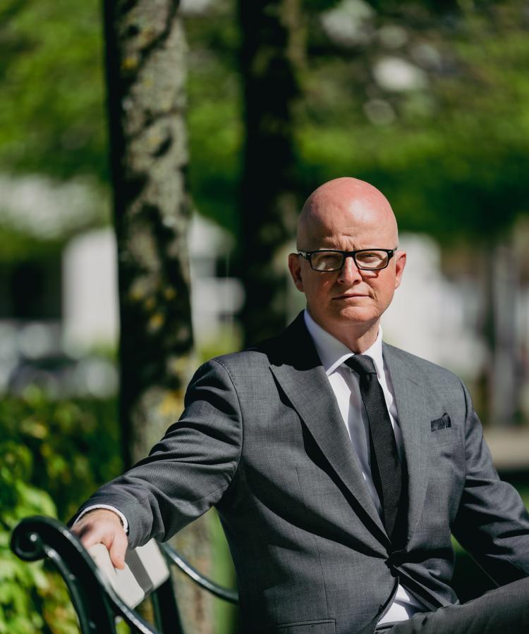 Portræt af Martin Nors Hansen, siddende på en bænk i en park