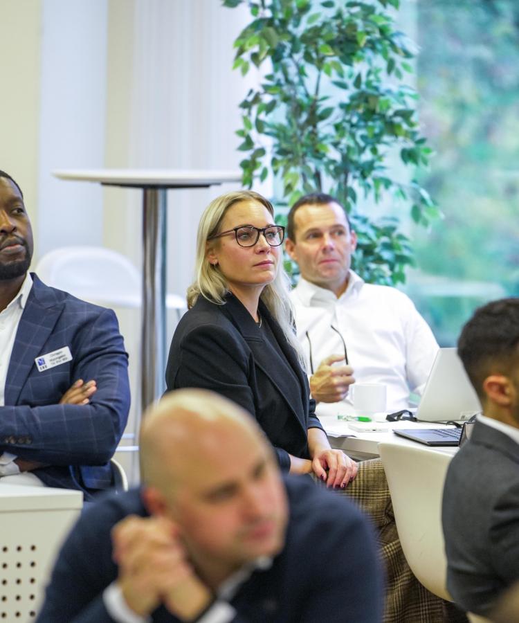 Blue MBA participants paying attention to lecture