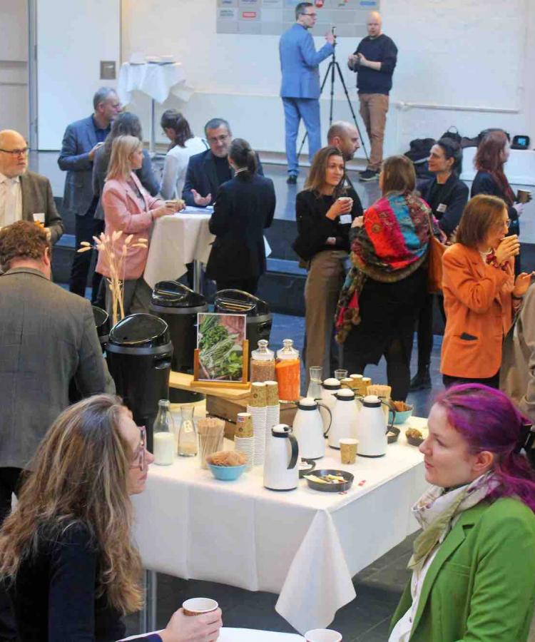 Publikum står rundt om bord med kaffe og netværker ved Agile And Adaptive Leadership konferencen