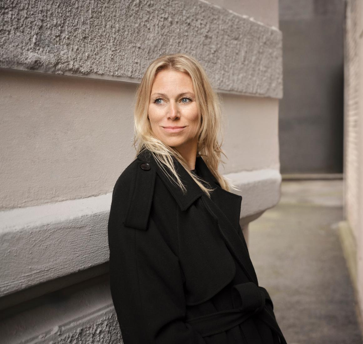 Portræt af Anna Bjerre mellem to stenfacader