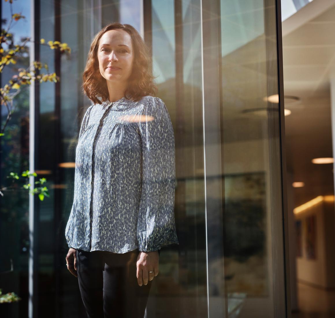 Portrait of Betina Doktor by a glass facade