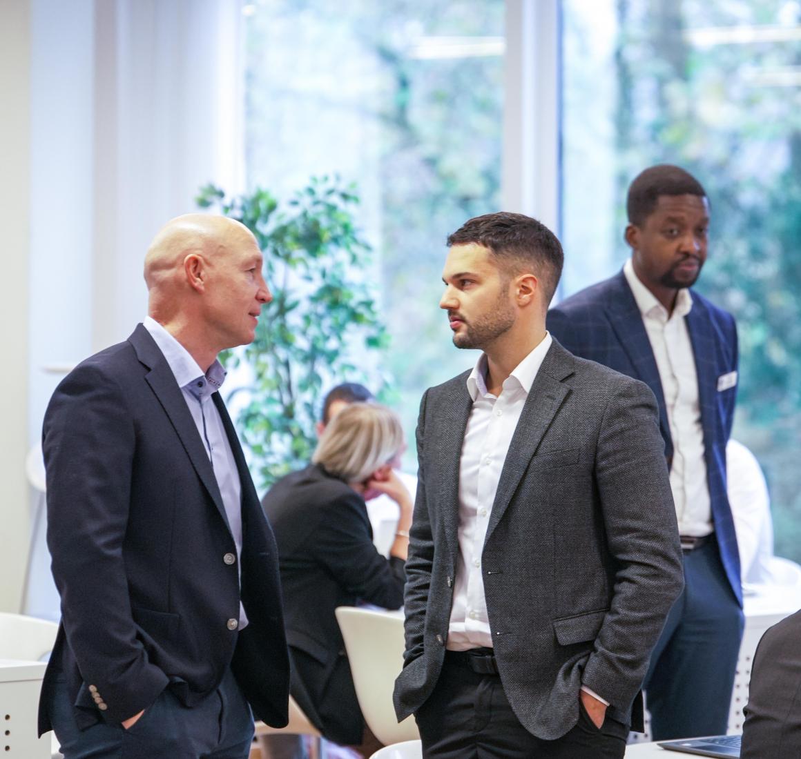 To Blue MBA-deltagere snakker i undervisningslokale