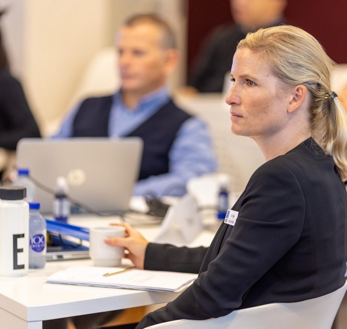 Liv Kjær, Blue MBA alumni, seated at a table during a classroom session