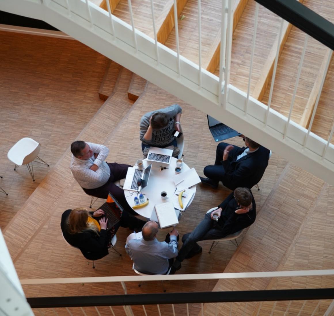 Participants at EMBA sitting around table, photographed from above