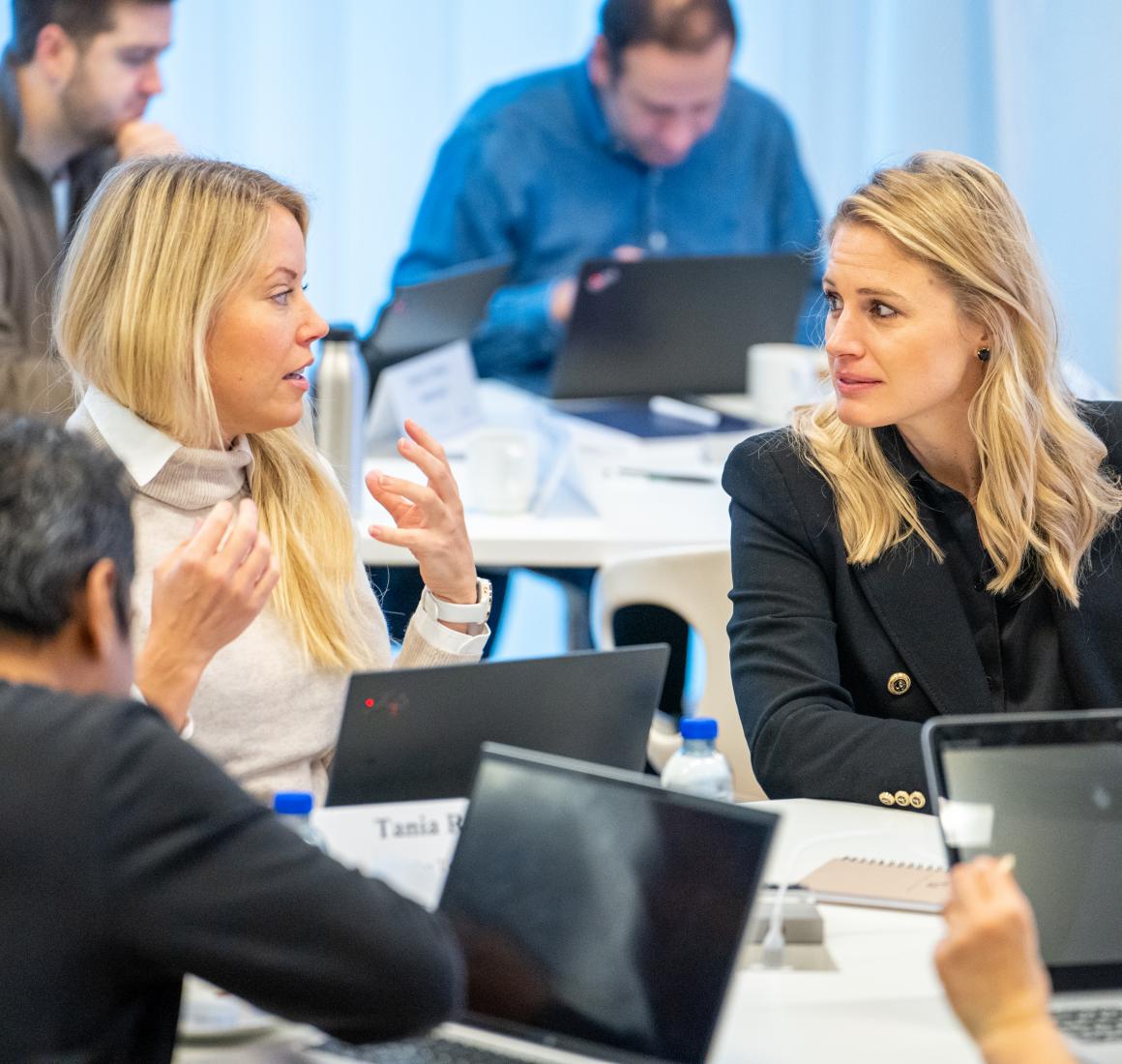 Two EMBA participants interracting in class