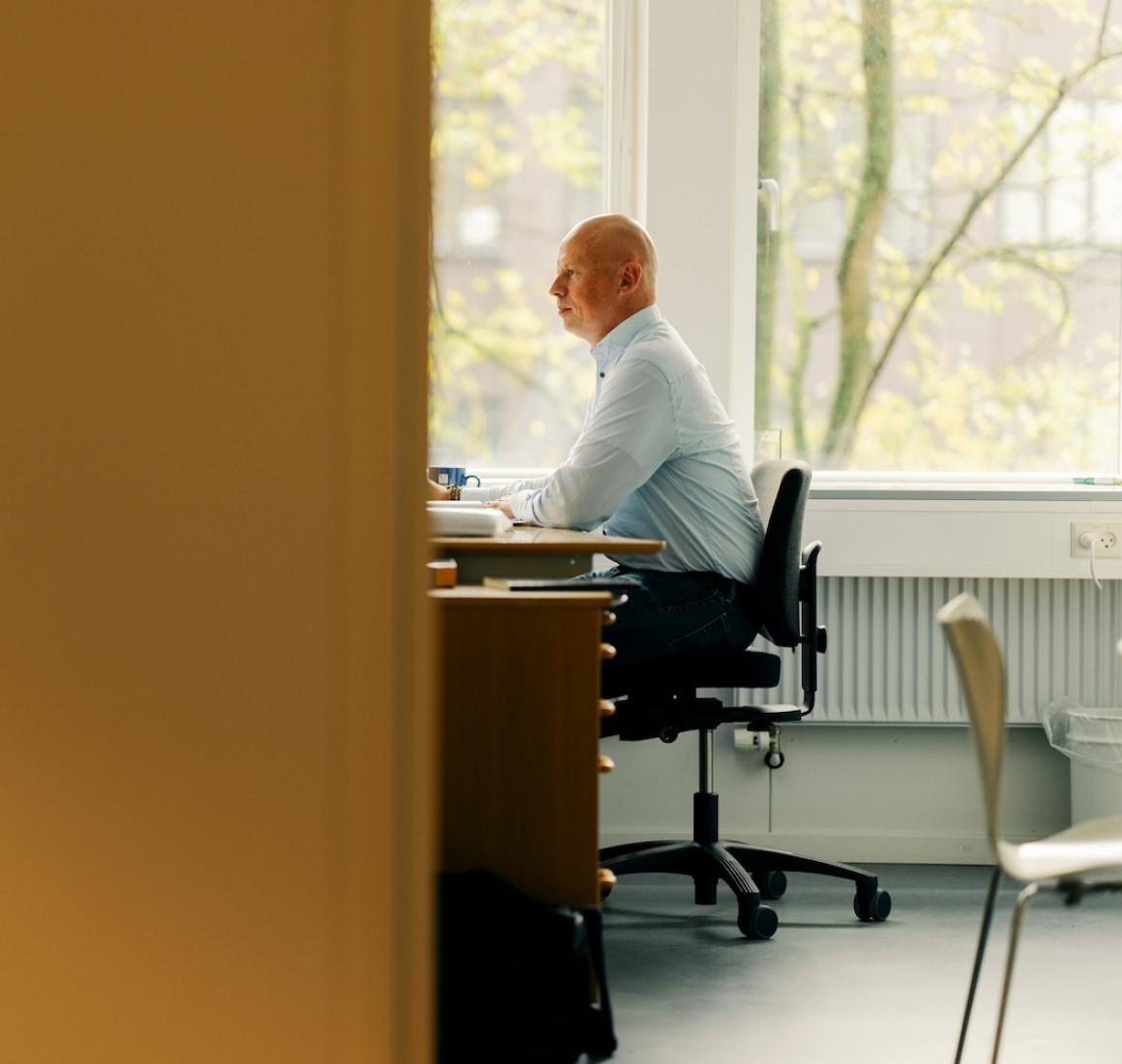 Mand sidder på kontorplads og arbejder