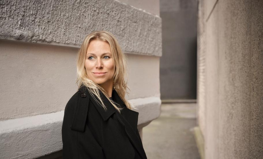 Portræt af Anna Bjerre mellem to stenfacader