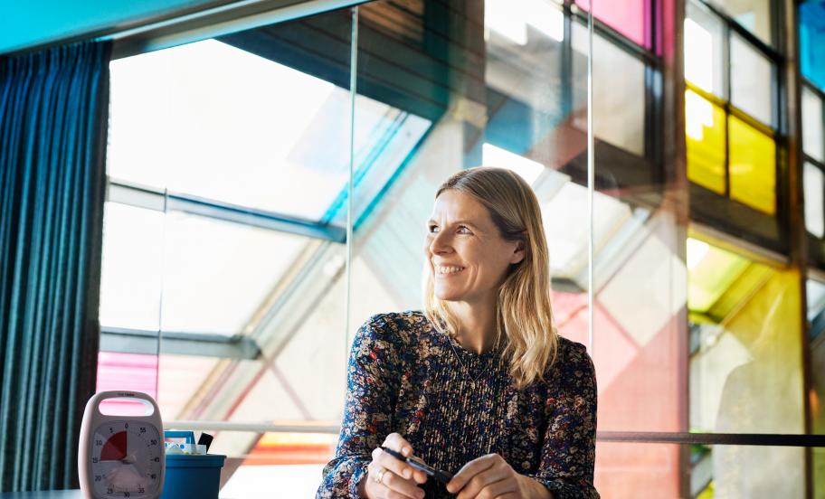 Portræt af Charlotte Matthiesen ved et vindue i et moderne interiør