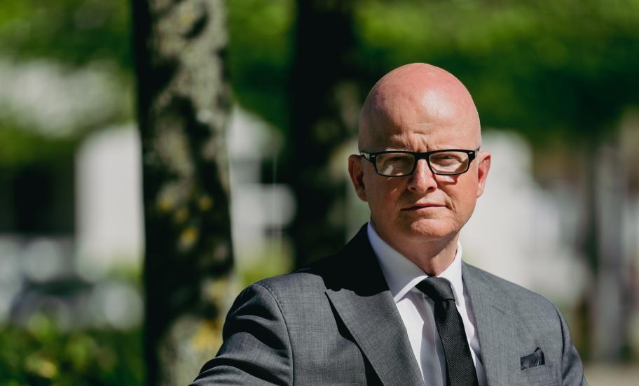 Portræt af Martin Nors Hansen, siddende på en bænk i en park