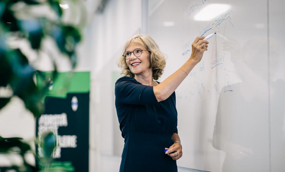 Professor Jane Bolander står ved tavle og underviser