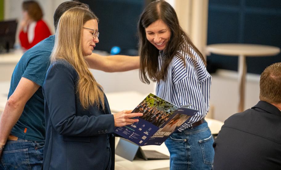 Image of CBS EMBA Participants looking at the Brochure