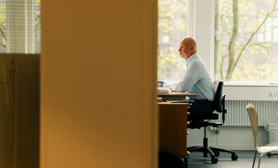 Mand sidder på kontorplads og arbejder
